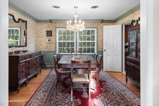 dining room featuring crown molding, a baseboard heating unit, a chandelier, and light wood-type flooring