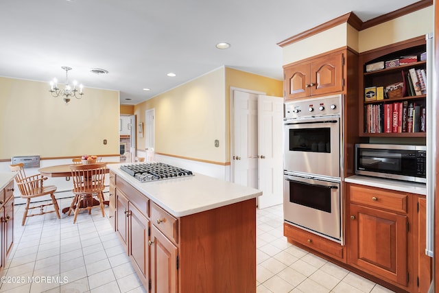 kitchen with light tile patterned flooring, hanging light fixtures, a center island, a notable chandelier, and stainless steel appliances