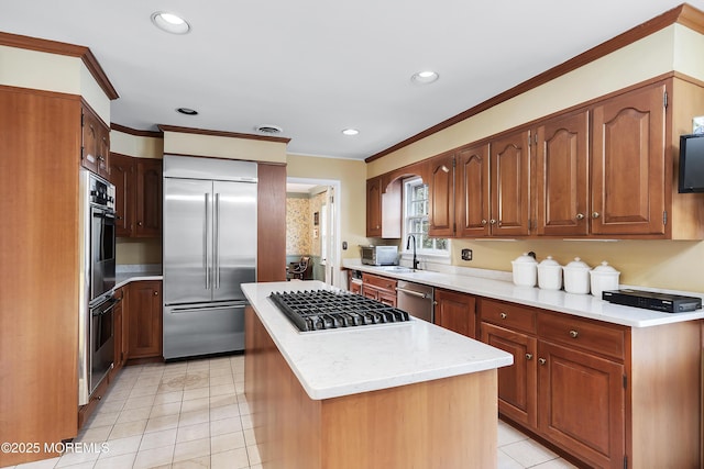 kitchen featuring ornamental molding, stainless steel appliances, sink, and a kitchen island