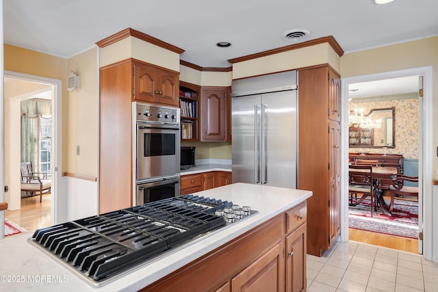 kitchen featuring stainless steel appliances, ornamental molding, and light tile patterned flooring