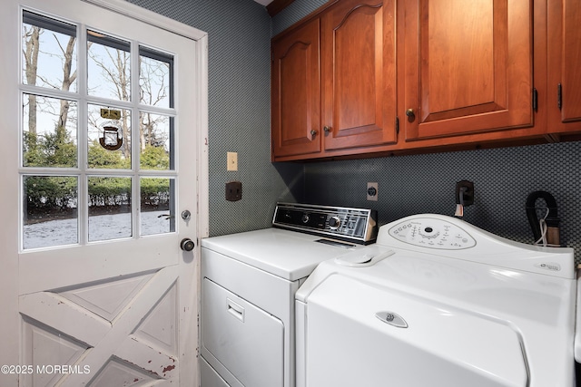 laundry room with independent washer and dryer and cabinets