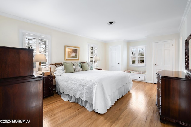 bedroom featuring ornamental molding and light hardwood / wood-style floors