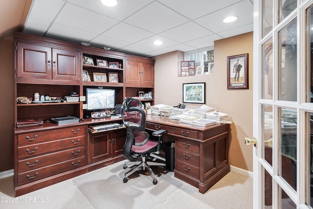 carpeted home office with a drop ceiling