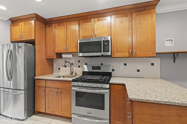 kitchen featuring light stone counters, sink, decorative backsplash, and appliances with stainless steel finishes