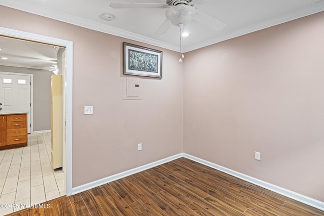 unfurnished room with light wood-style floors, ceiling fan, baseboards, and ornamental molding