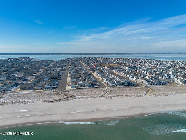 drone / aerial view featuring a residential view, a water view, and a beach view