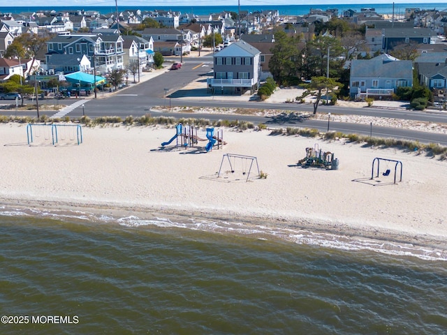 drone / aerial view featuring a water view and a beach view