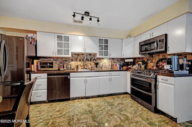 kitchen featuring stainless steel appliances, sink, white cabinets, and decorative backsplash