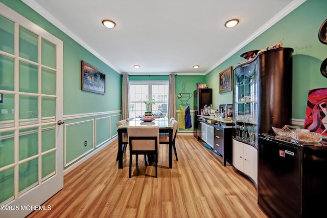 dining room featuring light hardwood / wood-style flooring and ornamental molding