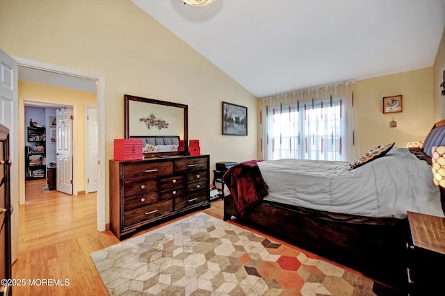 bedroom with lofted ceiling and light wood-type flooring