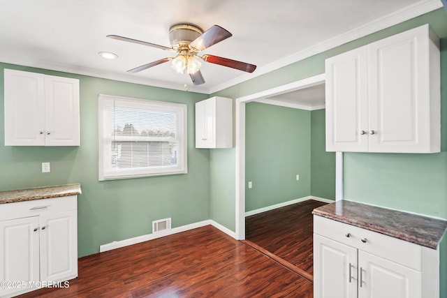 kitchen with white cabinetry, dark wood-type flooring, ceiling fan, and ornamental molding