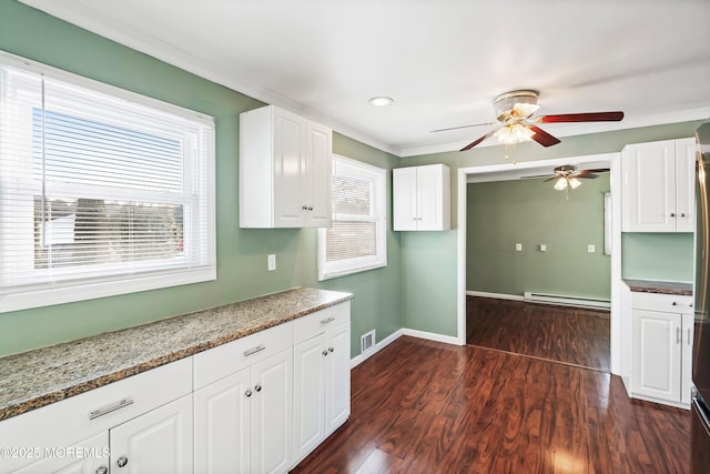 kitchen featuring baseboard heating, dark hardwood / wood-style floors, light stone counters, ornamental molding, and white cabinets