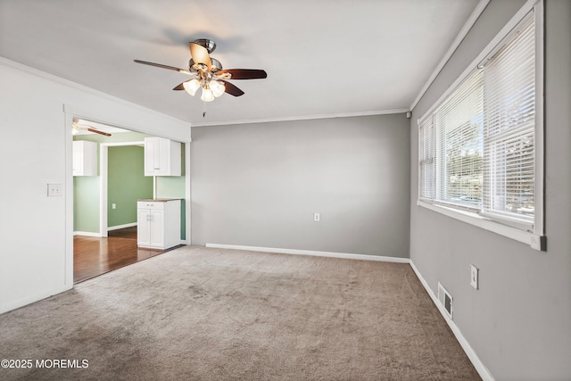 spare room featuring ornamental molding, carpet flooring, and ceiling fan