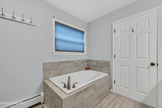 bathroom with a baseboard radiator and a relaxing tiled tub