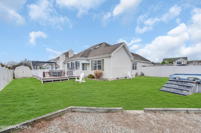 rear view of house featuring a wooden deck, a storage shed, and a lawn