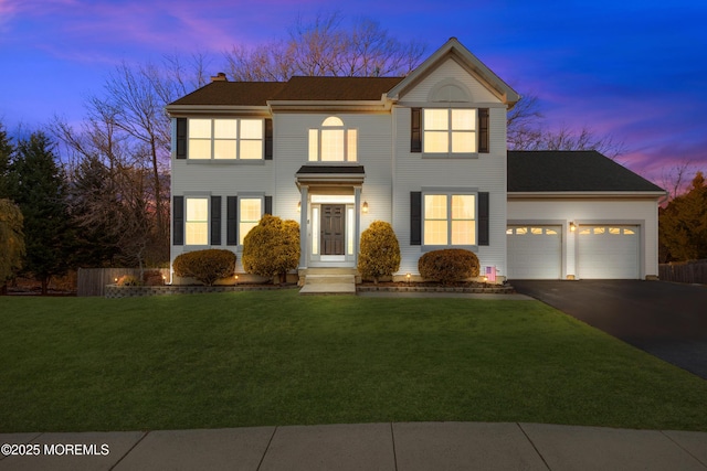 view of front of property featuring a garage and a yard