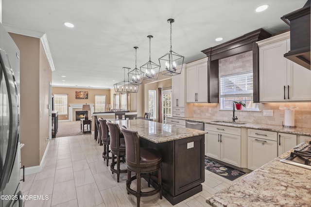 kitchen with a kitchen island, appliances with stainless steel finishes, sink, a breakfast bar area, and hanging light fixtures