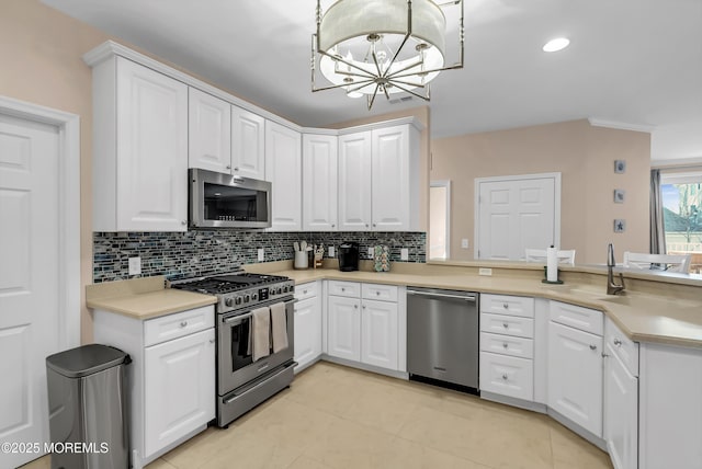 kitchen featuring decorative light fixtures, tasteful backsplash, white cabinetry, a notable chandelier, and stainless steel appliances