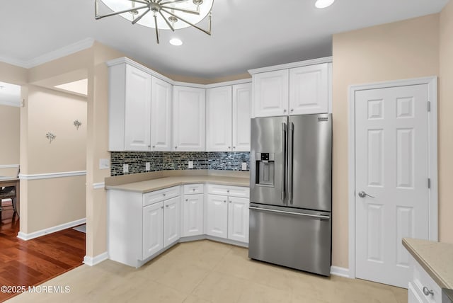 kitchen with white cabinetry, decorative backsplash, light hardwood / wood-style floors, crown molding, and high end fridge