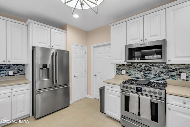 kitchen featuring white cabinetry, decorative backsplash, light tile patterned flooring, and appliances with stainless steel finishes