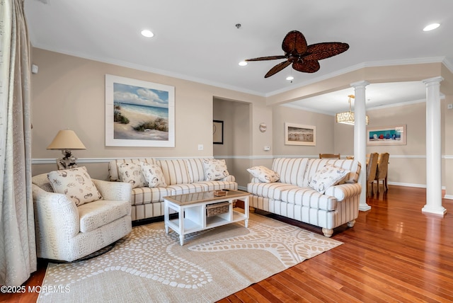 living room featuring crown molding, ceiling fan, decorative columns, and hardwood / wood-style flooring