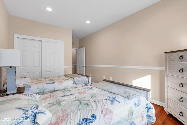 bedroom with dark hardwood / wood-style floors and a closet