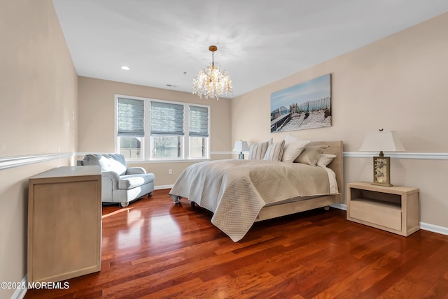 bedroom with a notable chandelier and dark wood-type flooring