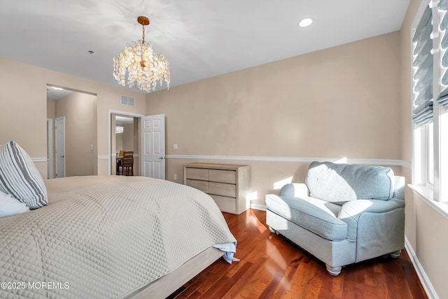 bedroom with dark hardwood / wood-style flooring and a notable chandelier