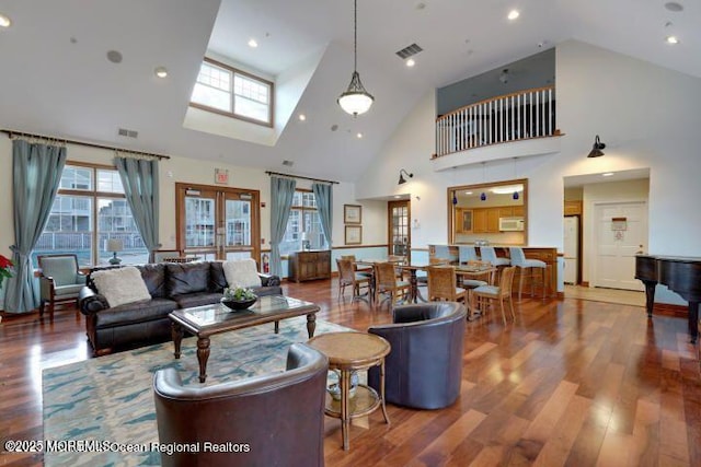 living room with hardwood / wood-style flooring and high vaulted ceiling