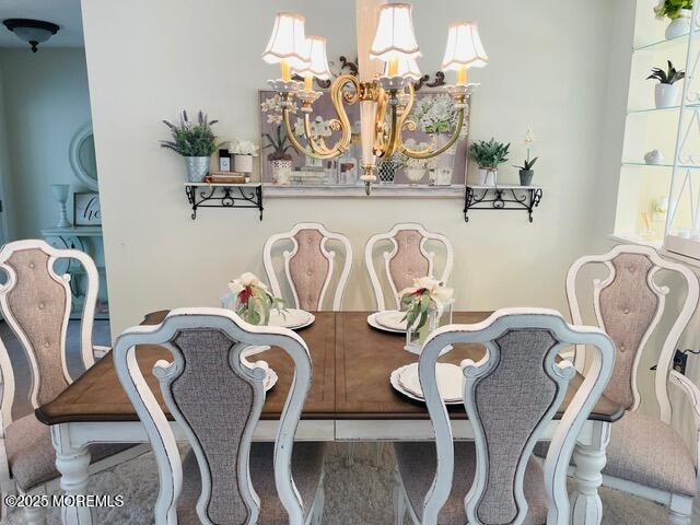 dining area featuring wood-type flooring and a chandelier