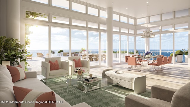 sunroom featuring a water view, a wealth of natural light, and a notable chandelier