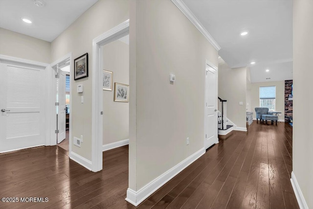 hallway with dark hardwood / wood-style flooring and ornamental molding