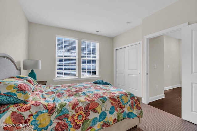 bedroom with dark hardwood / wood-style floors and a closet