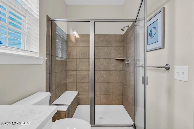 bathroom with a shower with door, vanity, and toilet