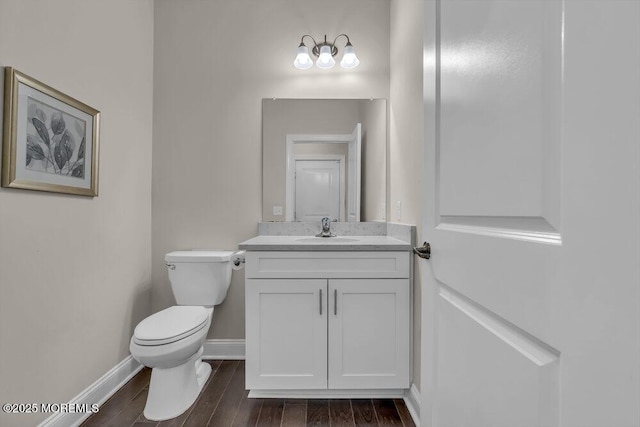 bathroom featuring vanity, hardwood / wood-style floors, and toilet