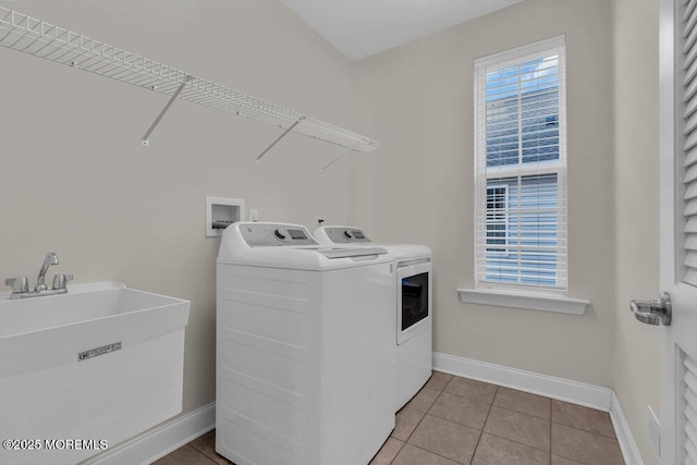 laundry area with sink, washer and clothes dryer, and light tile patterned flooring