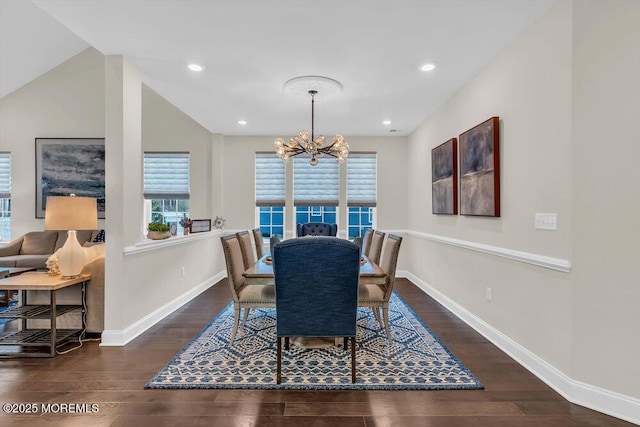 dining area with dark hardwood / wood-style flooring, vaulted ceiling, and a notable chandelier