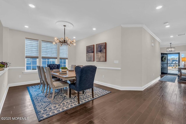 dining area featuring an inviting chandelier, dark wood-type flooring, and ornamental molding