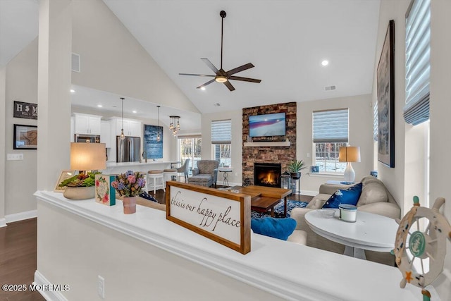 living room with dark hardwood / wood-style floors, a healthy amount of sunlight, a fireplace, and high vaulted ceiling