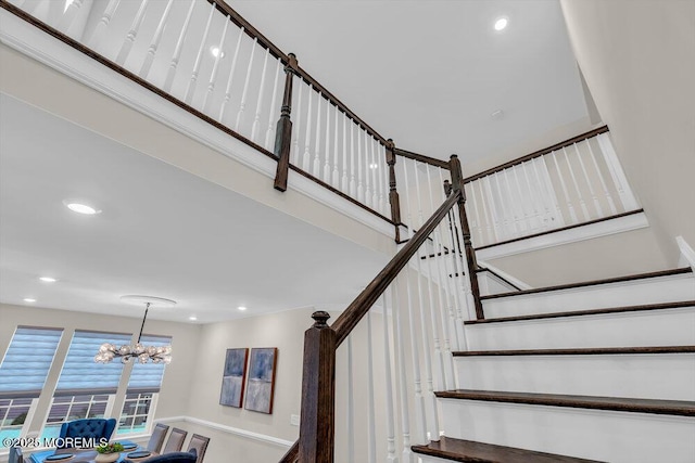 staircase with a notable chandelier