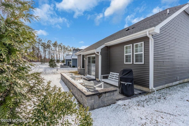 snow covered house featuring a patio