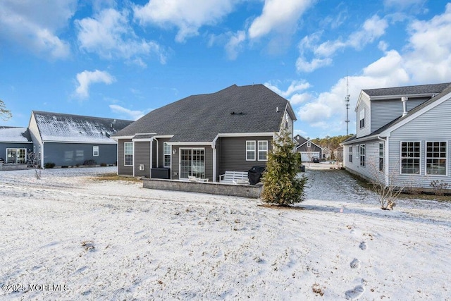 view of snow covered back of property