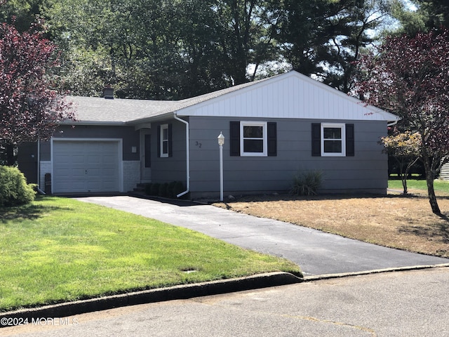 single story home featuring a garage and a front lawn