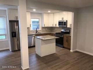 kitchen with sink, white cabinetry, a center island, a wealth of natural light, and stainless steel appliances