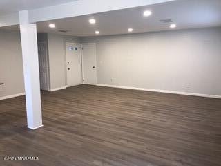 basement with dark hardwood / wood-style floors