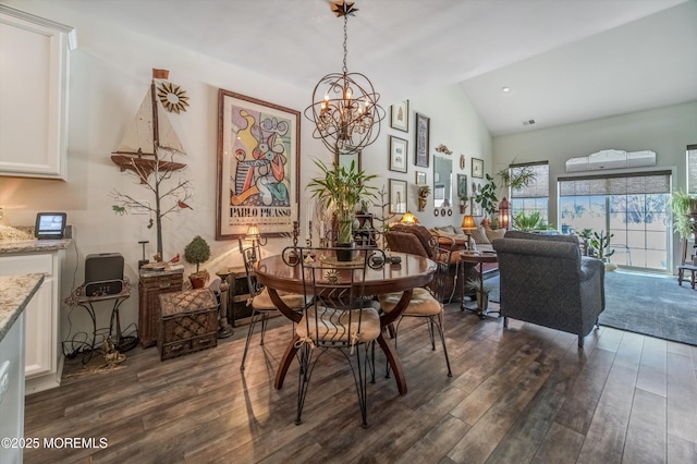 dining space with lofted ceiling, dark hardwood / wood-style flooring, and an inviting chandelier