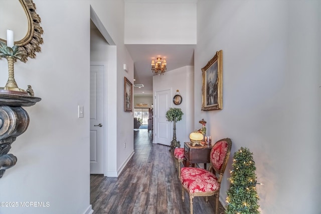 hallway featuring dark wood-type flooring and an inviting chandelier