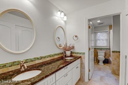 bathroom with vanity, toilet, and decorative backsplash