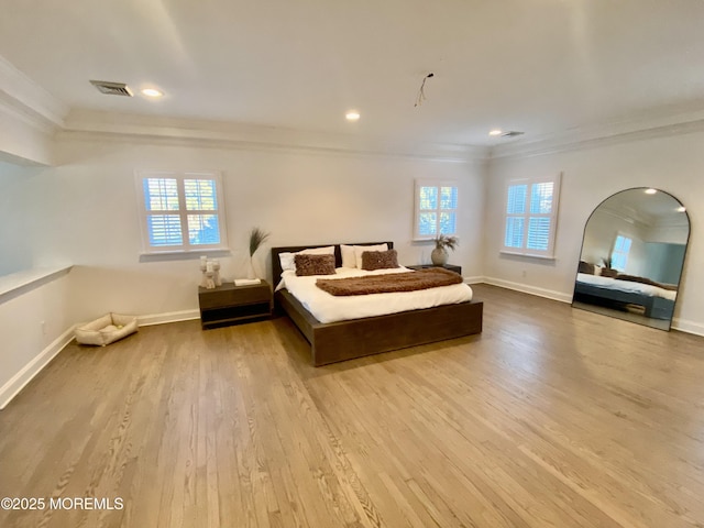 bedroom with ornamental molding and light hardwood / wood-style flooring