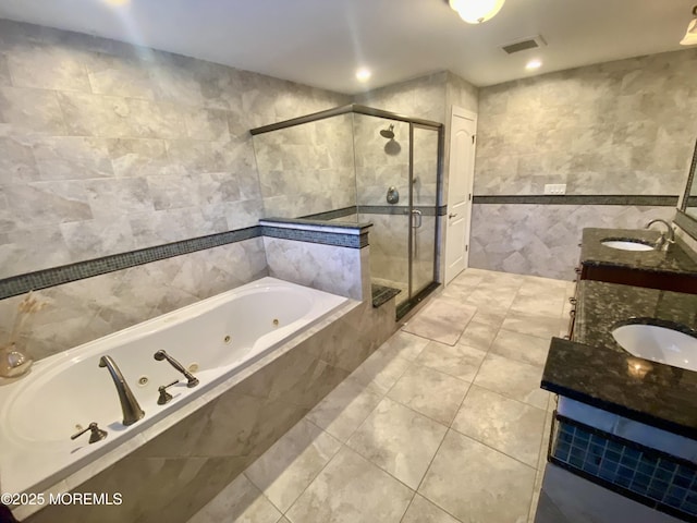 bathroom featuring vanity, plus walk in shower, tile patterned flooring, and tile walls